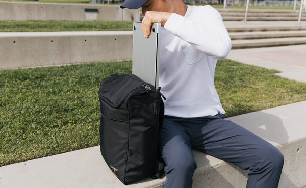 Person placing their laptop in the laptop compartment of the Cambiata.